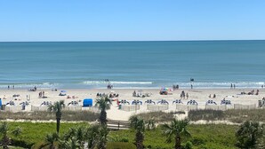 Una playa con gente, sombrillas y sillas de playa.