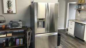 Una cucina moderna con un frigorifero in acciaio inossidabile, un tostapane e un dispenser d'acqua.