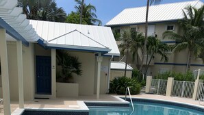 Una piscina con borde de azulejos, una escalera metálica y una puerta que indica 'No Diving'.