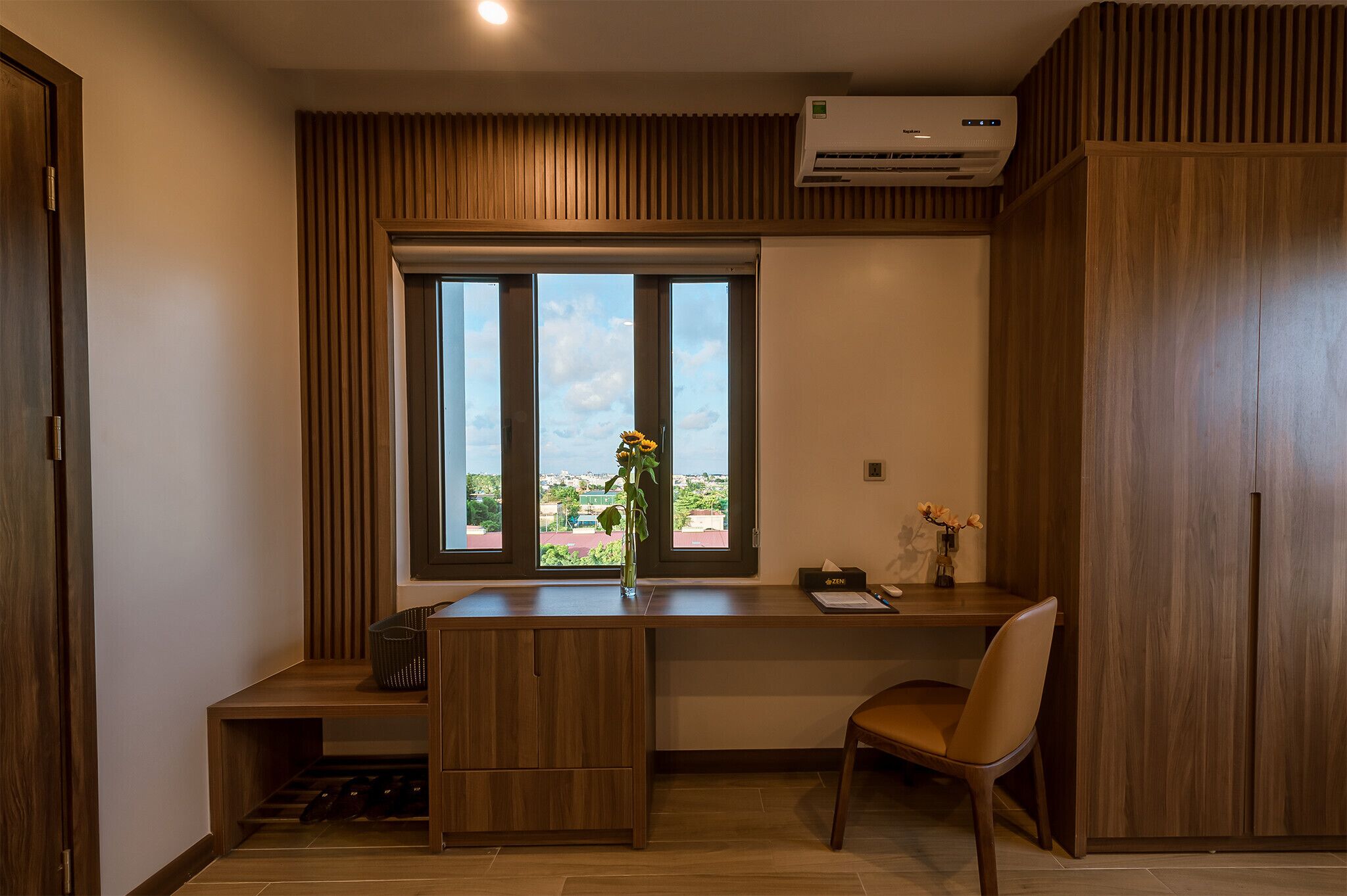 A modern office space with a desk, chair, and a window with a view.