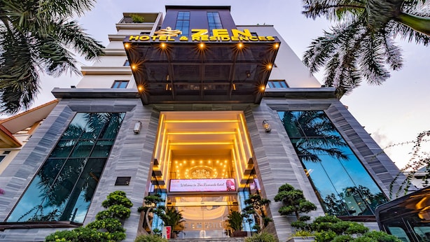 The Zen Hotel & Residences entrance with a modern design, featuring a large glass facade, a welcoming entrance with a sign, and a well-maintained garden area. - Zen Riverside Hotel & Residences (Hai Phong)