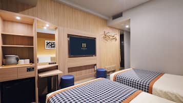 A hotel room with two beds, a desk, a television, and a wardrobe.