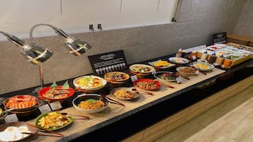 A buffet with various dishes and a sign indicating food allergies.