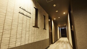 A hallway with directional signs and a carpeted floor. - hotel MONday Asakusa (Tokyo)
