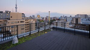 A rooftop terrace with a view of a city skyline, including a prominent tower and various buildings. - hotel MONday Asakusa (Tokyo)