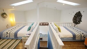 A room with two beds, a staircase, a small table, and a wall-mounted shelf. - Byeolmuri Pension (Hoengseong)