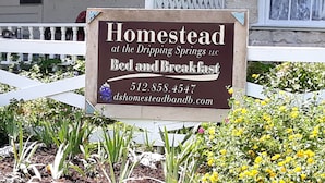 A sign for Homestead Bed and Breakfast with contact information. - Butler Cabin at The Homestead B&B  (Dripping Springs,)