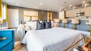 A modern bedroom with a large bed, a desk, and a kitchenette. - ⚜️Stylish,Spacious & Comfortable Downtown Penthouse! Enjoy The View from Your Personal Terrace! (New Orleans)