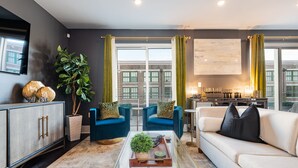 A modern living room with a sofa, armchairs, a coffee table, and a cabinet. - ⚜️Stylish,Spacious & Comfortable Downtown Penthouse! Enjoy The View from Your Personal Terrace! (New Orleans)