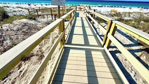 A wooden boardwalk leading to a beach with a sign indicating it is private property.