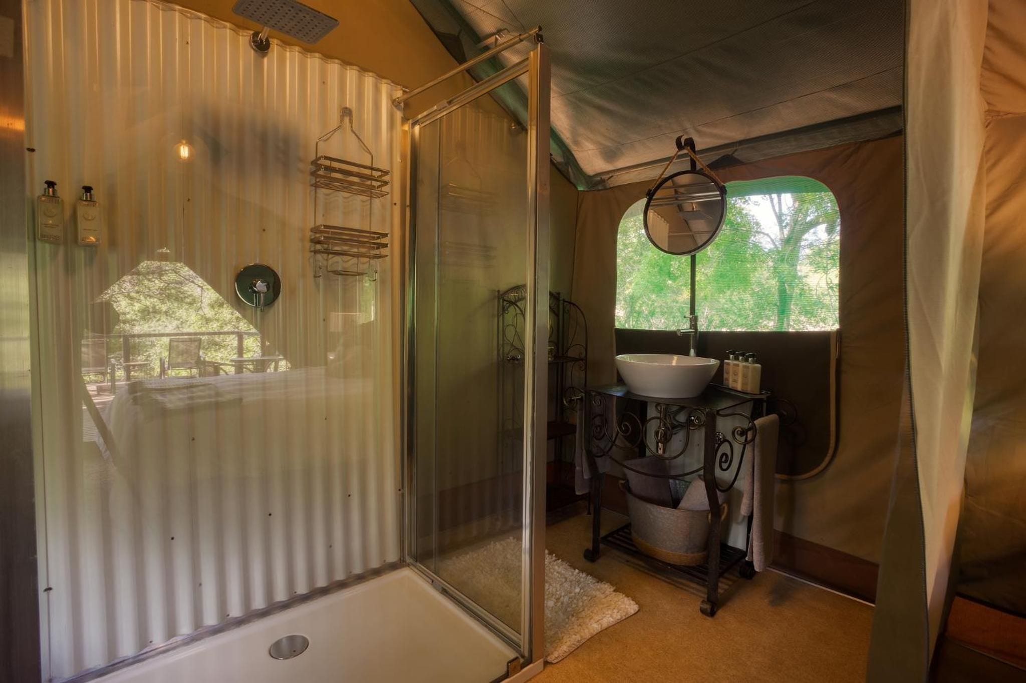 A compact bathroom with a shower enclosure, a sink, and a mirror.