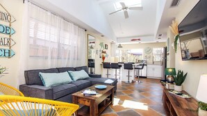 A spacious living area with a sofa, coffee table, and a dining area with bar stools. - 3BR Captiva Cottage with Hot Tub & Steps to the Beach (Captiva)