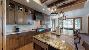 A spacious kitchen with wooden cabinets, a granite countertop, and a large island.