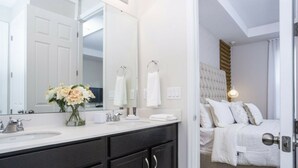 A modern bathroom with a large mirror, two sinks, and a dark vanity. - Colorful & Unique Private Pool 1561 (Kissimmee)