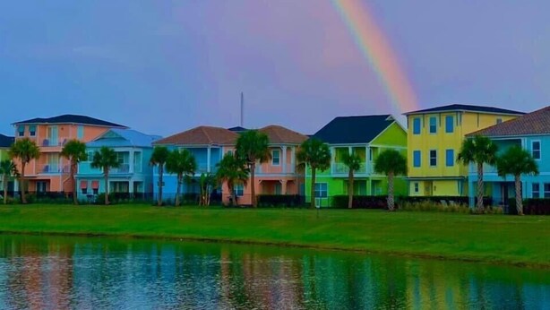 Una fila di case colorate con un arcobaleno riflesso sull'acqua.