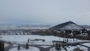 A snowy mountain landscape with a road and buildings in the foreground.