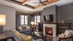 A modern living room with a fireplace, sofas, a coffee table, and a television.