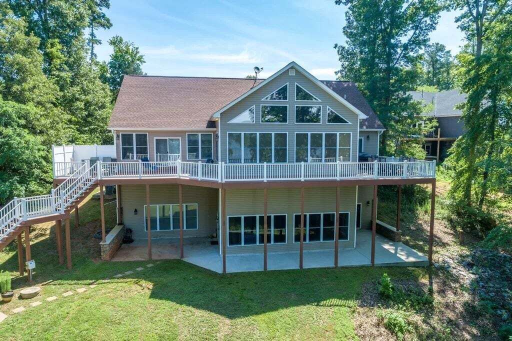 A two-story house with a balcony, a covered porch, and a staircase leading to the upper level.