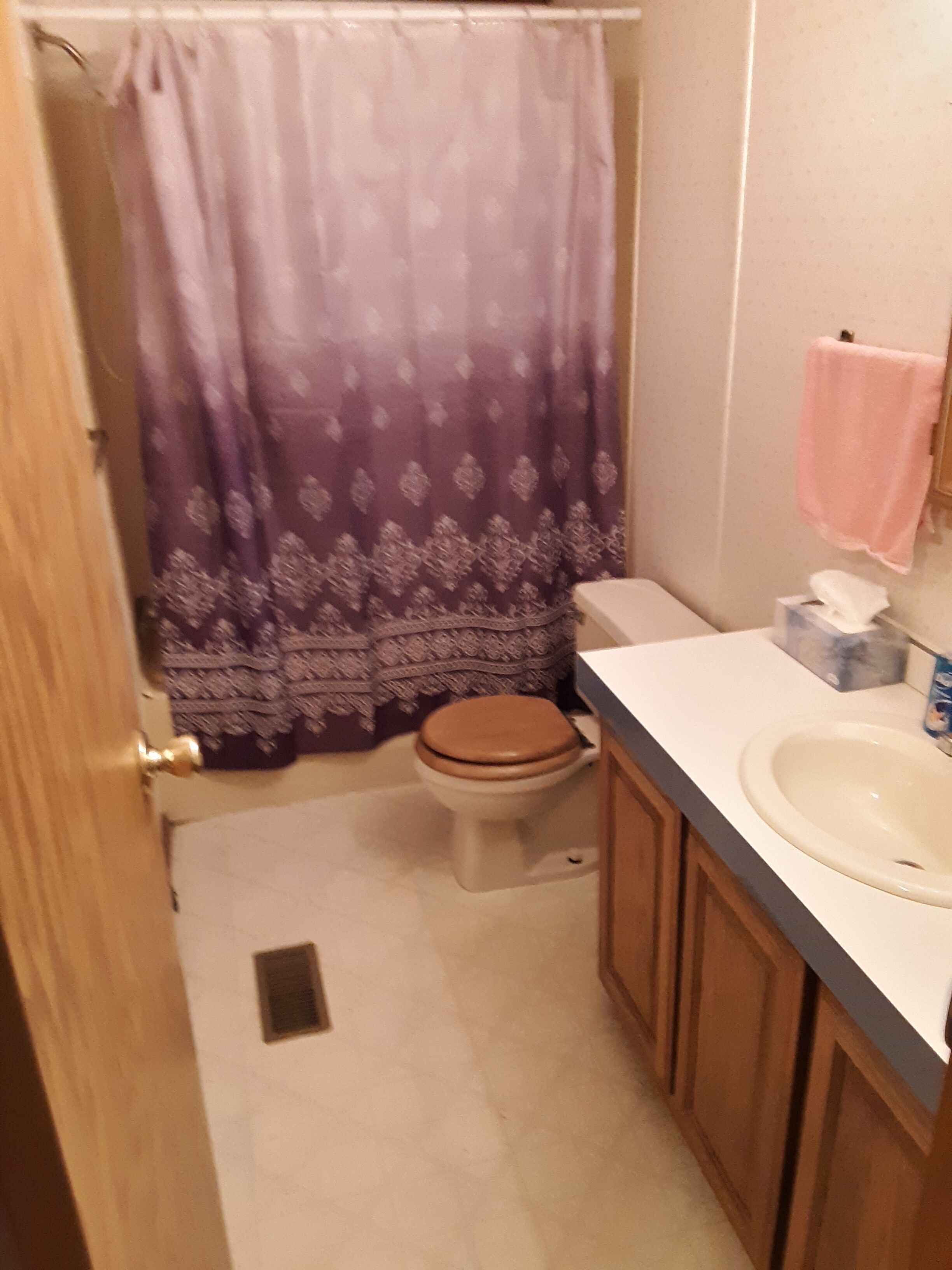 Een badkamer met toilet, wastafel en douchegordijn.