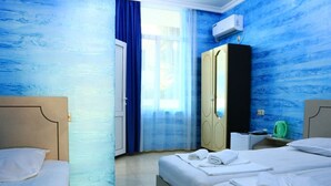 A hotel room with two beds, a wardrobe, a window with blue curtains, and a green kettle on the nightstand. - Tamara bed and breakfast :-) (Batumi)