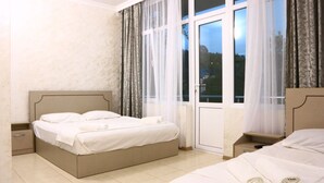 A hotel room with a bed, a nightstand, a window with curtains, and a view of the outdoors. - Tamara bed and breakfast :-) (Batumi)