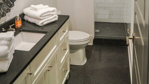 A modern bathroom with a black countertop, white sink, and a large mirror. - Home Away from Home! Beautiful Carriage House in Seagrove Close to the Beach (Santa Rosa Beach)
