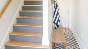 A staircase with wooden steps and a handrail, leading to a door with a towel hanging on the wall. - Home Away from Home! Beautiful Carriage House in Seagrove Close to the Beach (Santa Rosa Beach)