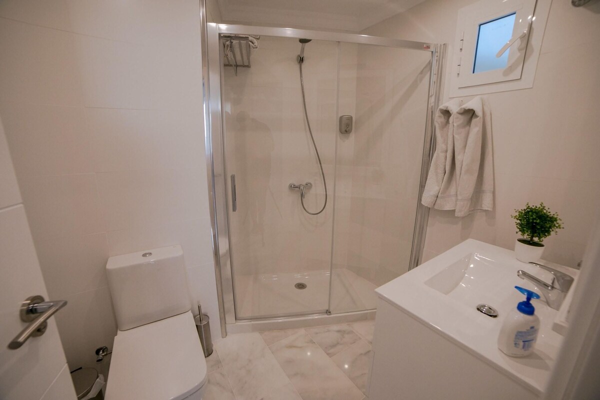 Une salle de bain moderne avec une douche à parois de verre, des toilettes et un lavabo avec un miroir.