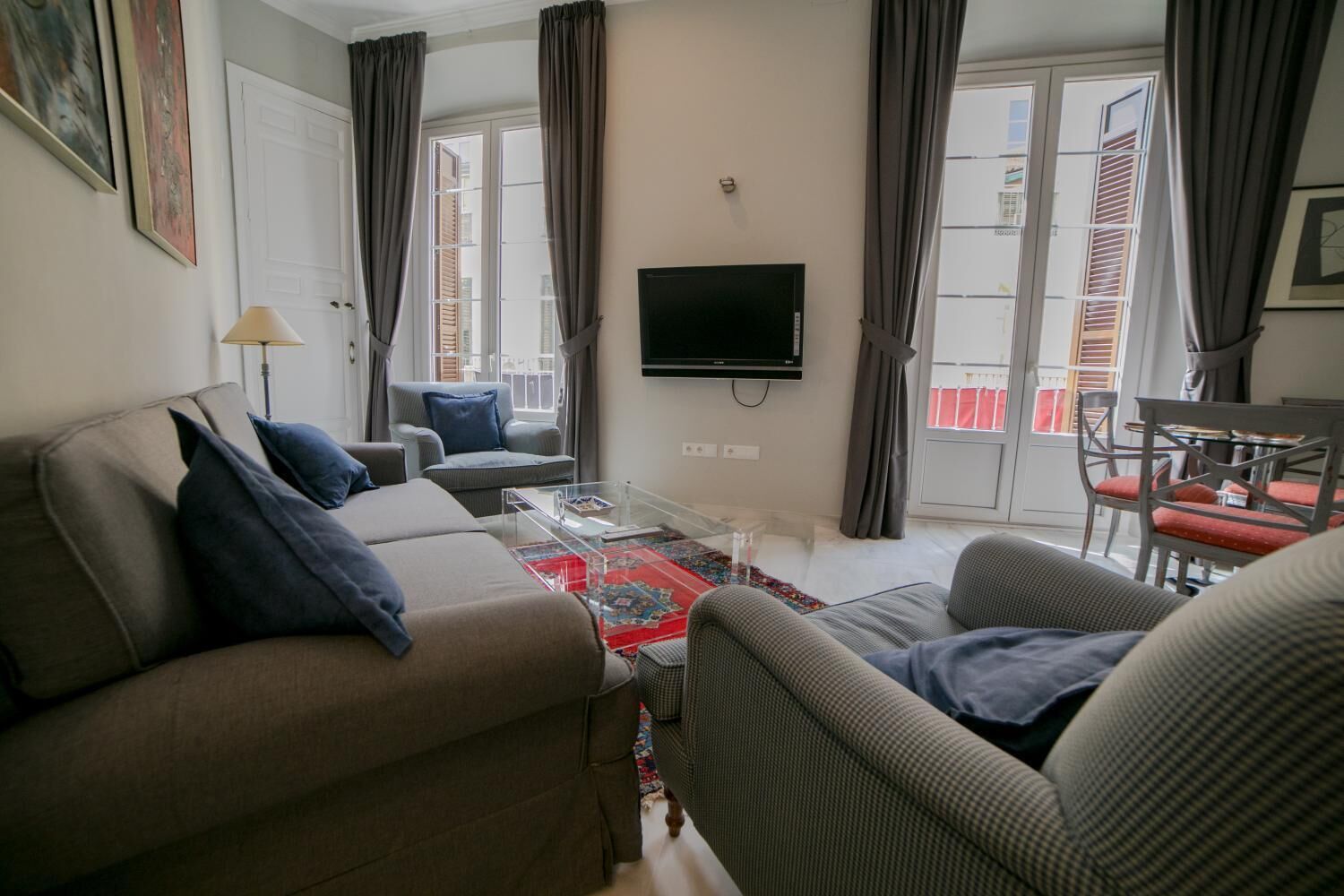 A living room with a sofa, armchairs, a coffee table, and a TV.