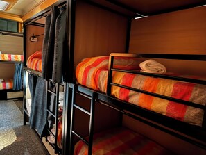 A bunk bed room with a wooden headboard, a small table, and a curtain. - Host Bari centrale - Hostel (Bari)