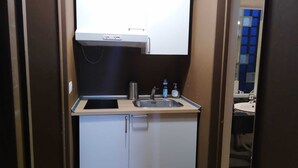 A compact kitchenette with a sink, a small cabinet, and a bottle of hand soap. - Dolci Emozioni (Bari)