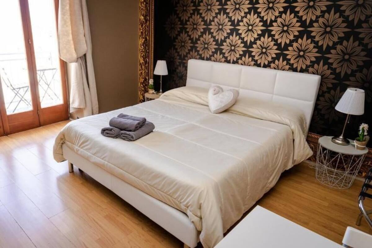Une chambre d’hôtel avec un grand lit, une petite table et une vue sur l’extérieur grâce à une porte coulissante.