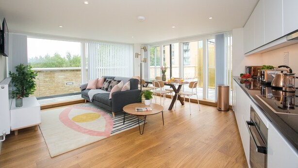 A modern kitchen with a dining area, a sofa, and a large window. - Moonside - Stunning Angel Apartments (London)