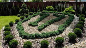 A hotel sign with a spiral garden in front. - Usługi Noclegowe 17 (Ostrow Mazowiecka)
