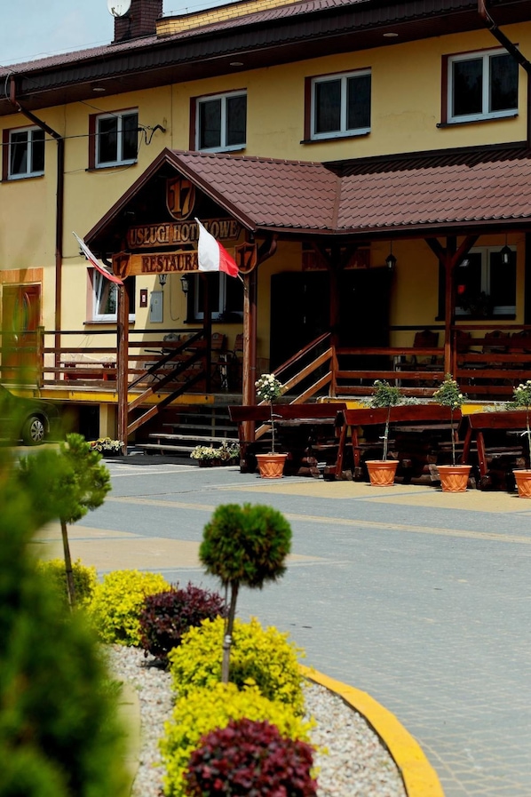 A yellow building with a sign reading "Uslugi Hotelowe Restauracja".