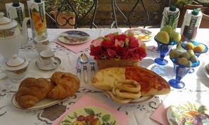 Una mesa servida con comida y bebidas, incluyendo cruasanes, pizza y zumos envasados.