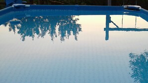 A clear view of a swimming pool with a visible deck and a reflection of trees. - B&B Villa Milena (Ariano Irpino)