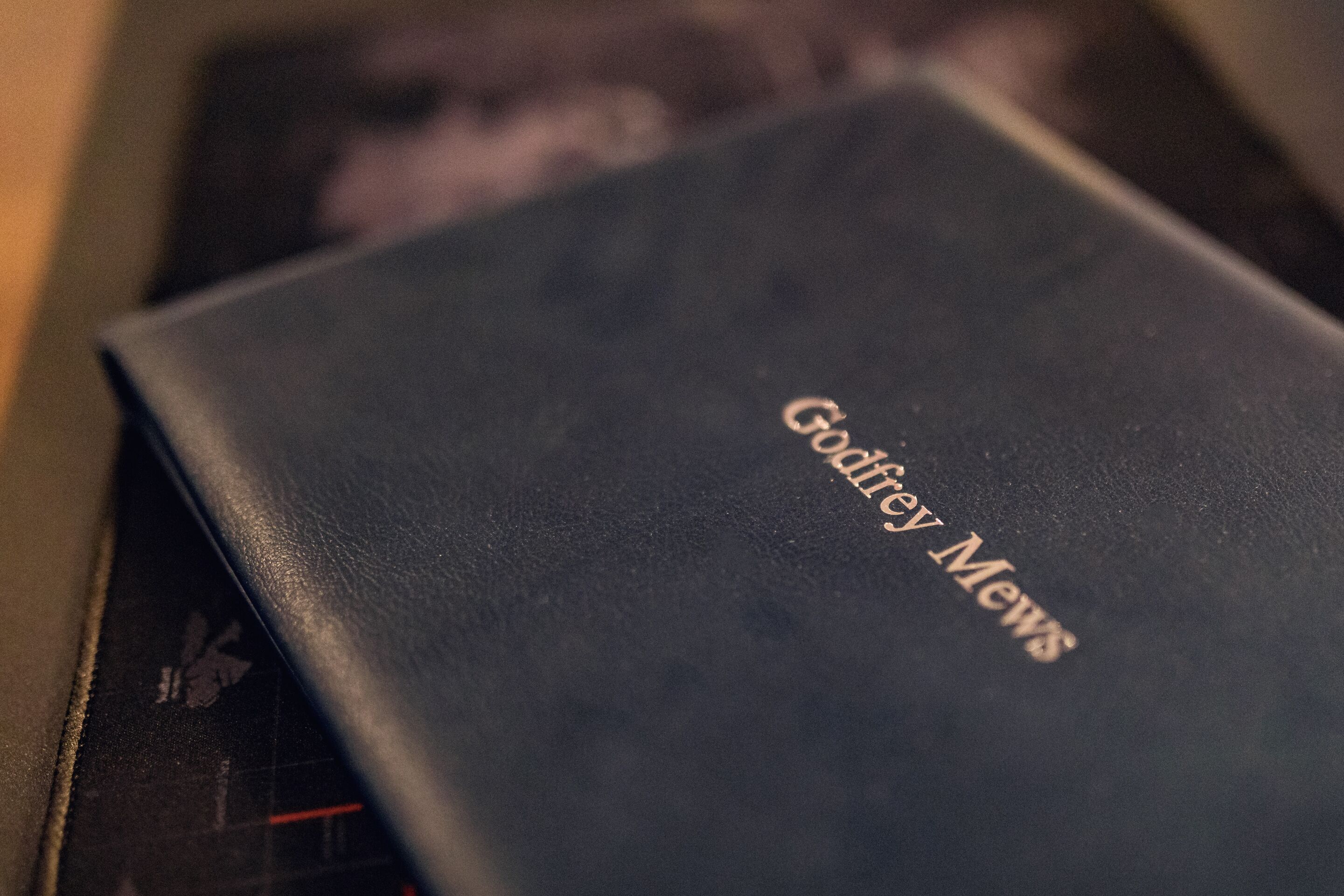 A black book with the title "Godfrey Mews" on its cover.