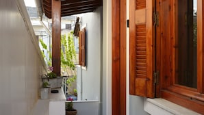 A narrow corridor with wooden shutters and a tiled floor. - Urban Studios Manos (Chania)