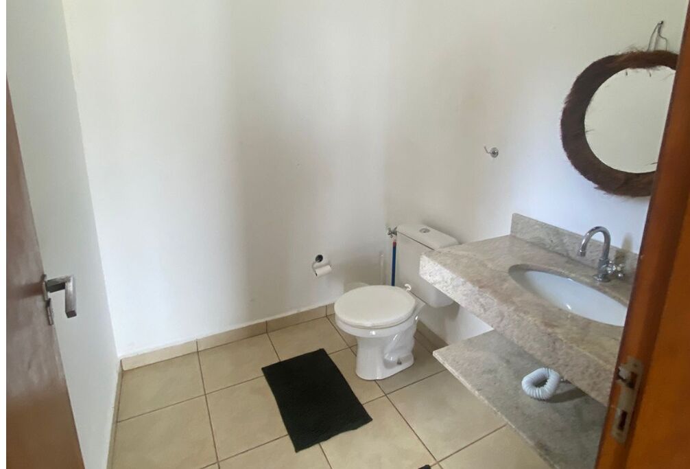 A small bathroom with a toilet, sink, and mirror.