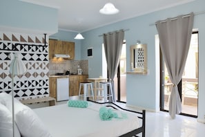 Ein modernes Schlafzimmer mit Bett, Schreibtisch und einer kleinen Küche.