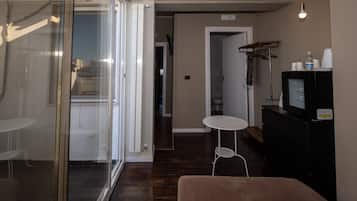 Habitación triple, balcón (4) | Área de sala de estar | Televisión de pantalla plana de 32 pulgadas con canales por cable