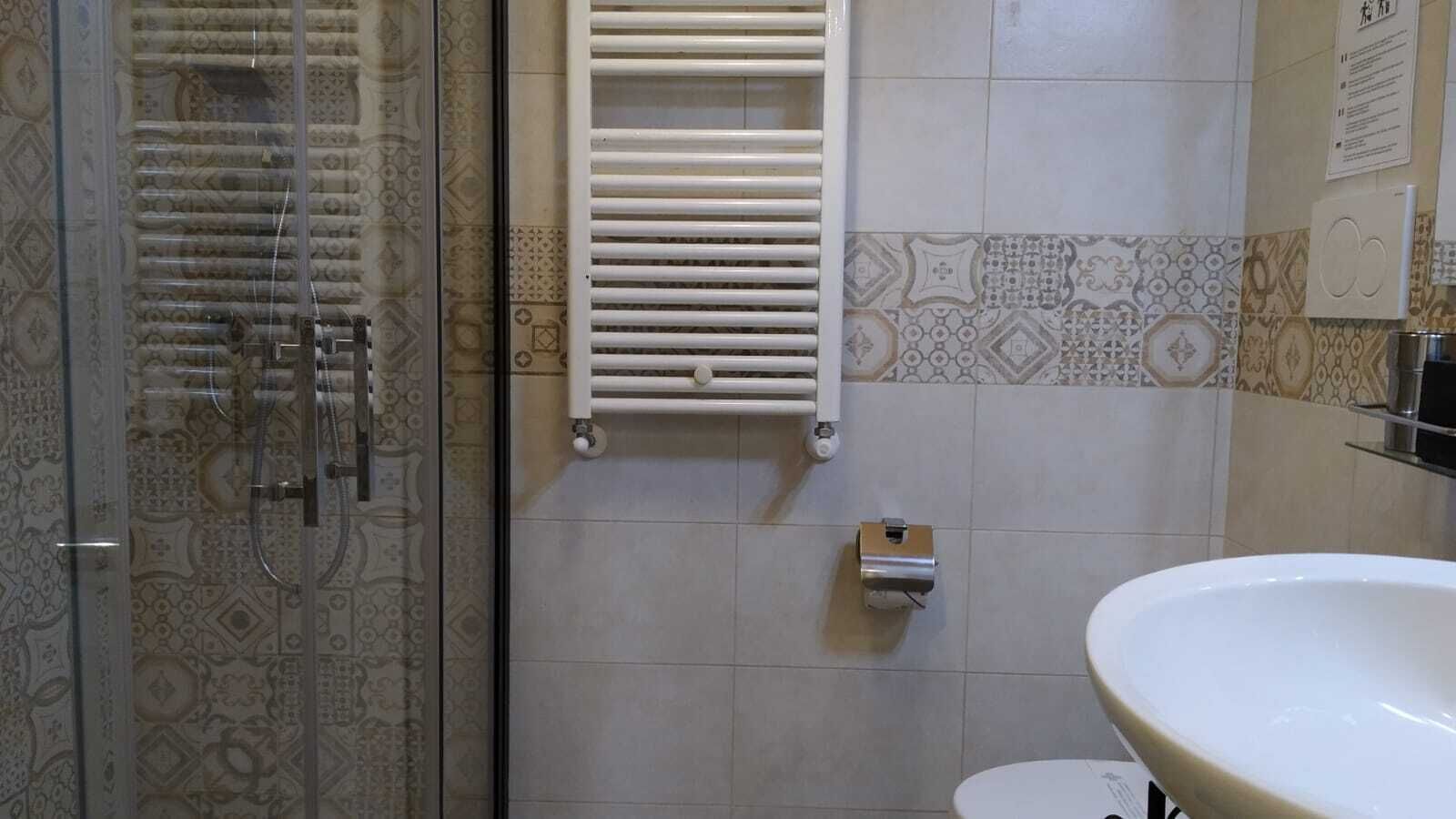 Une salle de bain avec douche, toilettes et lavabo.