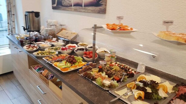 A buffet with various food items including fruits, salads, and meats. - Altstadt-Garni (Bad Windsheim)