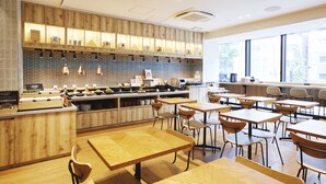 A modern restaurant with wooden furniture and a brick backsplash. - hotel MONday Akihabara Asakusabashi (Tokyo)