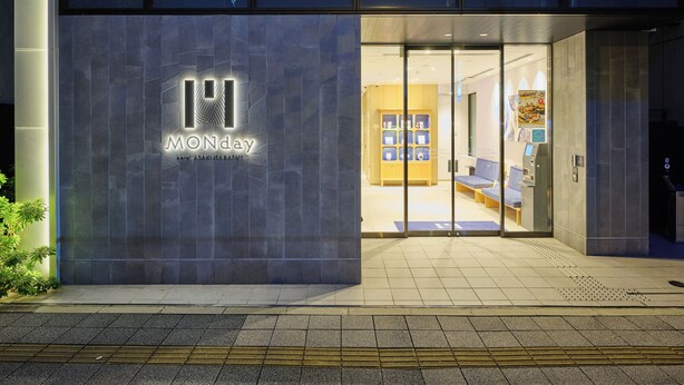 A hotel entrance with a modern design, featuring a prominent logo and a reception area with seating and a display case. - hotel MONday Akihabara Asakusabashi (Tokyo)