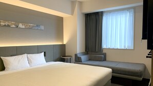 A hotel room with a large bed, a smaller sofa, a side table, and a window with curtains. - hotel MONday Akihabara Asakusabashi (Tokyo)