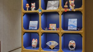 A display case with various cultural items including books, figurines, and traditional masks. - hotel MONday Akihabara Asakusabashi (Tokyo)