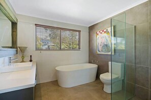 Een bad, handdoeken, zeep, toiletpapier