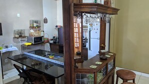 Uma cozinha com ilha central, balcão de madeira e geladeira.